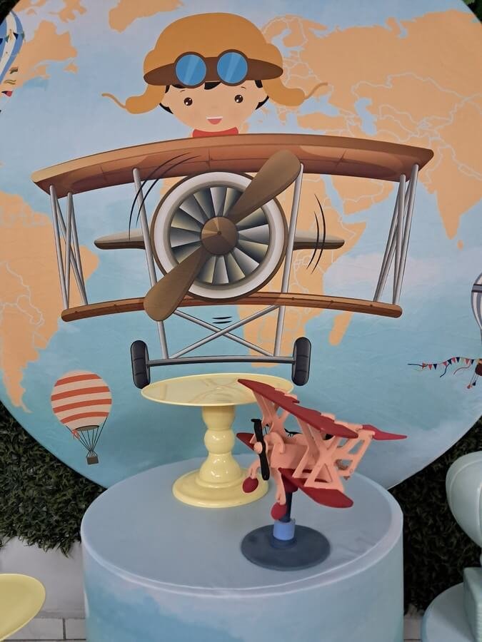 Kit completo de decoração afetiva e lúdica no estilo "Pegue e Monte" com a temática Aviador. Baseado na imagem real, o conjunto conta com um painel redondo gigante ilustrando um lindo macaquinho aviador em seu avião vintage sob um mapa-múndi e balões de ar quente. Acompanha trio de cilindros totalmente envelopados e coordenados com o tema (estampas de nuvens, aviões e mapas), suportes elevados para doces em tom amarelo suave, miniatura colecionável de avião de madeira e um vasinho decorativo em formato de balão de ar quente cerâmico. Kit completo de decoração afetiva e lúdica no estilo "Pegue e Monte" com a temática Aviador. Baseado na imagem real, o conjunto conta com um painel redondo gigante ilustrando um lindo macaquinho aviador em seu avião vintage sob um mapa-múndi e balões de ar quente. Acompanha trio de cilindros totalmente envelopados e coordenados com o tema (estampas de nuvens, aviões e mapas), suportes elevados para doces em tom amarelo suave, miniatura colecionável de avião de madeira e um vasinho decorativo em formato de balão de ar quente cerâmico.<br />